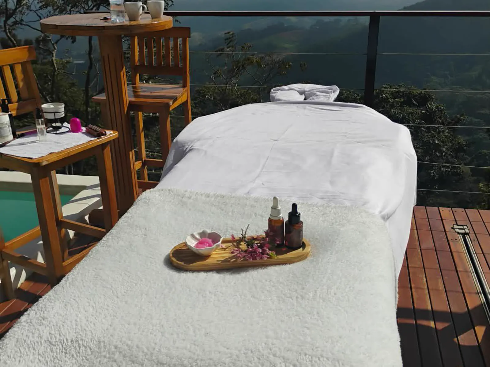 Maca de massagem montada no deck, com óleos e a serra ao fundo