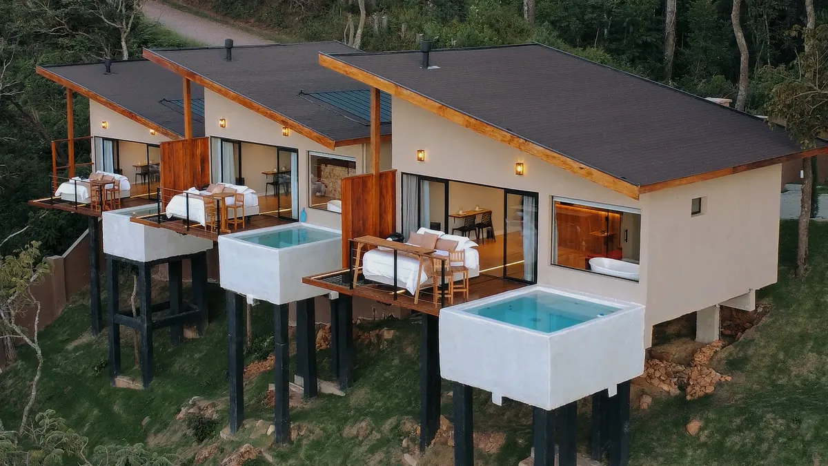 As três cabanas na encosta, cada uma com seu deck e piscina